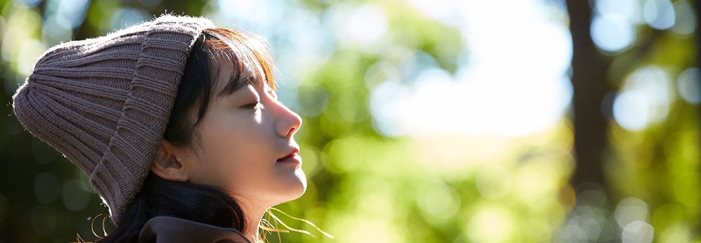 woman in hat outside with eyes closed