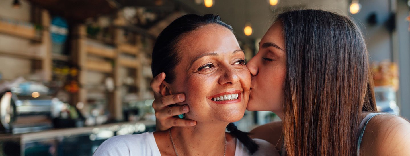 teen daughter kissing mom