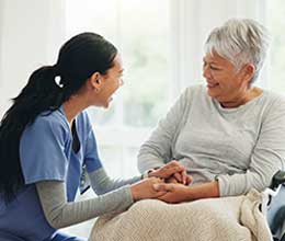 woman and caregiver holding hands