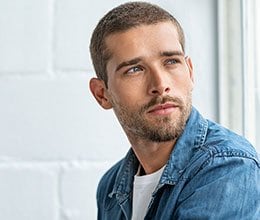 thoughtful man against a brick wall