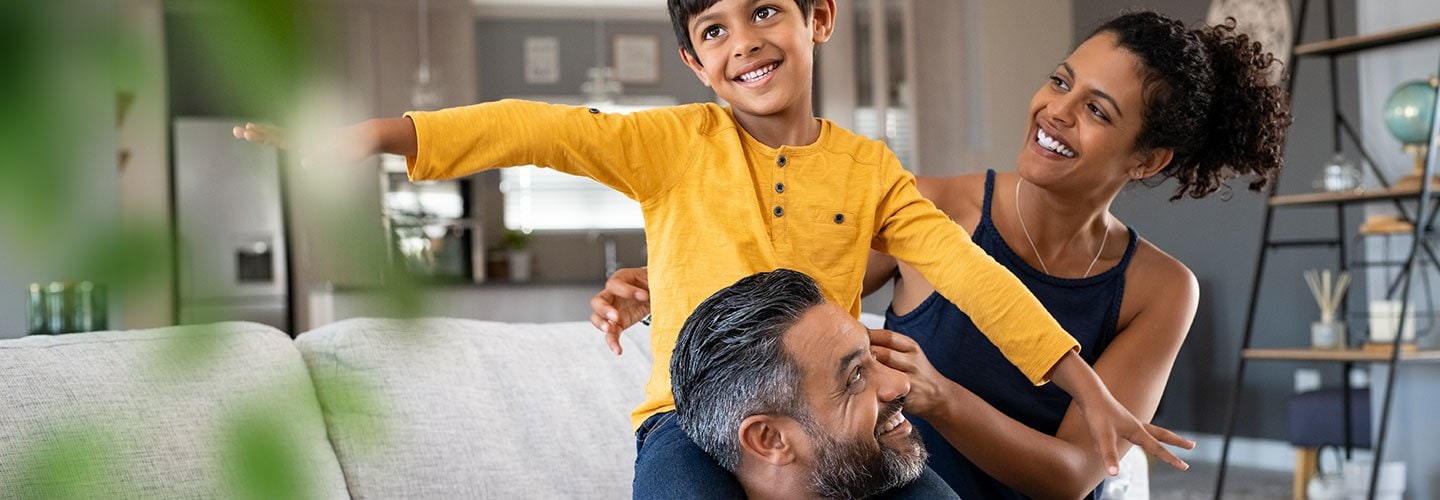 little boy sitting on father's shoulders