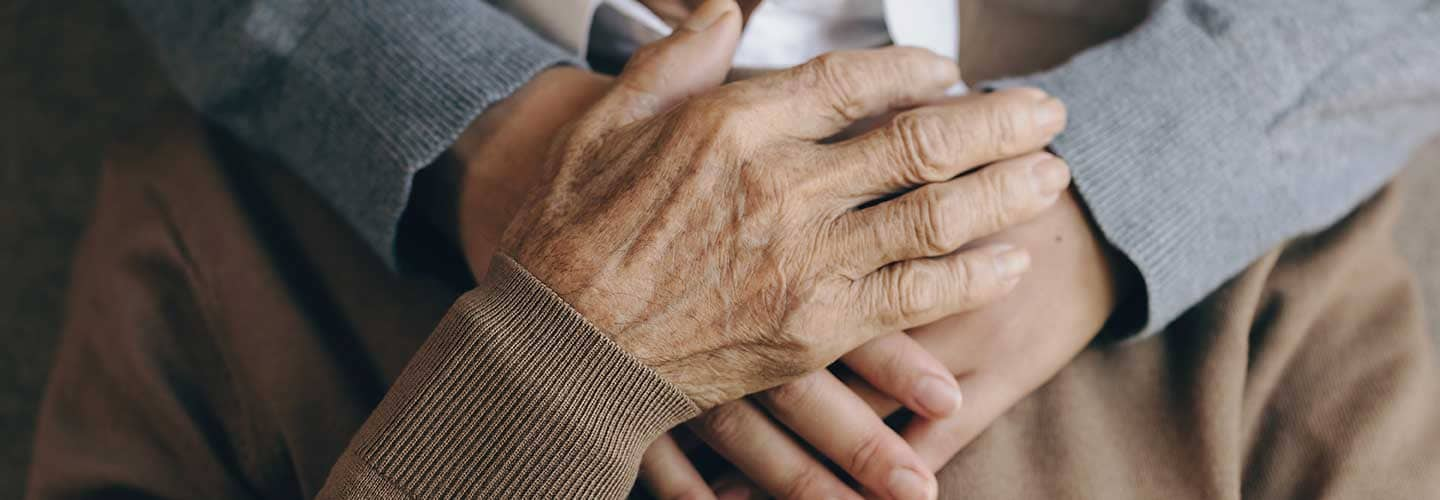 older man and younger person holding hands