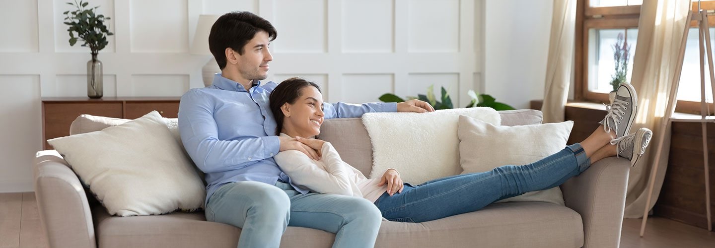 couple sitting on couch, gazing out window