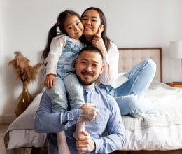 family smiling on bed